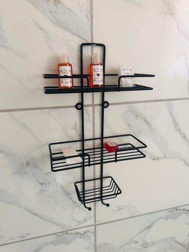 a bathroom shelf with cosmetics on a marble wall at The Pool_deck apartment in Lebowakgomo