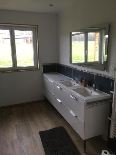 une salle de bain avec deux lavabos et deux fenêtres dans l'établissement Gîte Le clos du bannet, à Givonne