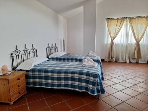 a bedroom with a bed with a blue and white blanket at Appartamento a due passi dal golf in Fubine