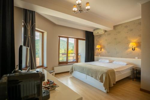 a bedroom with a bed and a desk and a television at Opus View in Sinaia