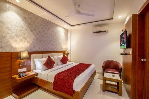 a hotel room with a bed and a chair at Hotel Arch Suites - Near Aerocity in New Delhi