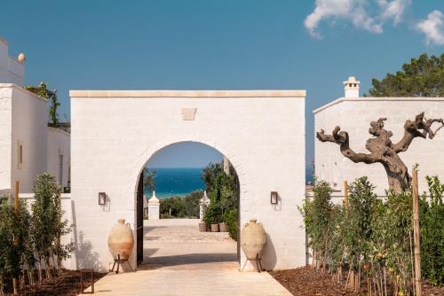 an entrance to a white building with an archway at Masseria Auraterrae in Polignano a Mare