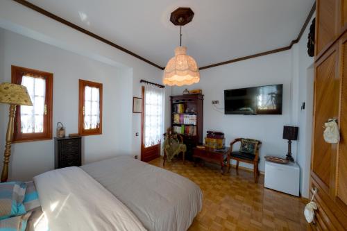 a bedroom with a white bed and a desk at Archontiko Alexandros Luxury Suites in Kardiá