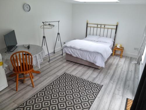 a bedroom with a bed and a table and a chair at Holiday Out House in London