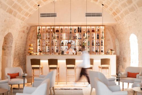 a man standing behind a bar in a restaurant at Masseria Auraterrae in Polignano a Mare