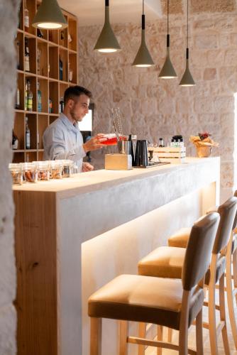 a man standing at a counter in a bar at Masseria Auraterrae in Polignano a Mare