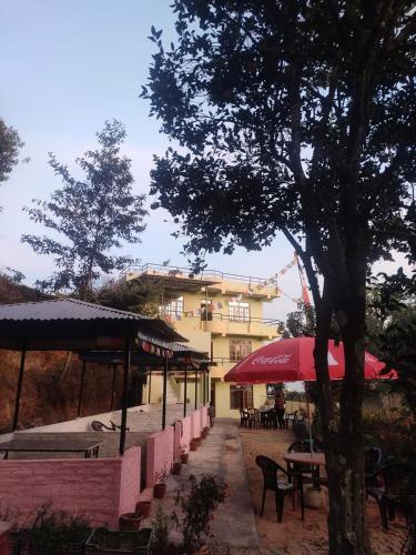 a patio with tables and umbrellas and a building at Hotel Swornim Namobuddha in Dhulikhel