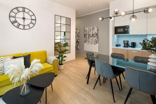 uma sala de estar com um sofá amarelo e uma mesa em Beautiful Apartment with 2 bedrooms for 7 guests, Jewish District em Cracóvia