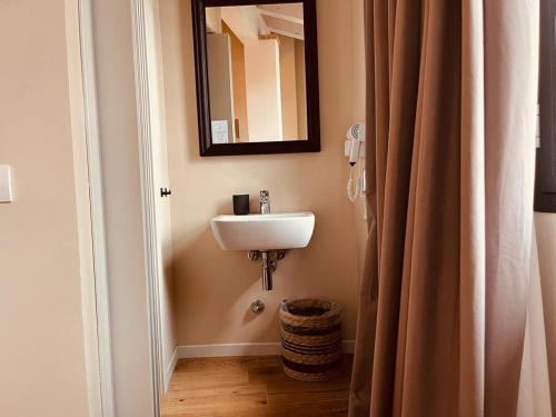 a bathroom with a sink and a mirror at Locanda Gatto Bianco in Bergamo