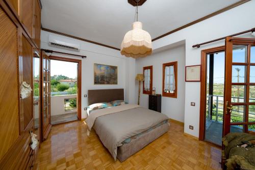 a bedroom with a bed and a large window at Archontiko Alexandros Luxury Suites in Kardiá