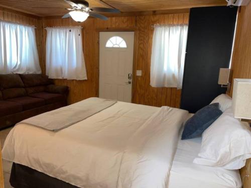 een slaapkamer met een groot wit bed en een bank bij Bixby Cove Cabin #2 in Porum
