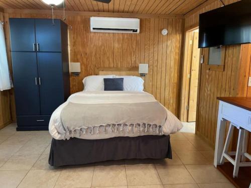 een slaapkamer met een groot bed en een blauwe kast bij Bixby Cove Cabin #2 in Porum