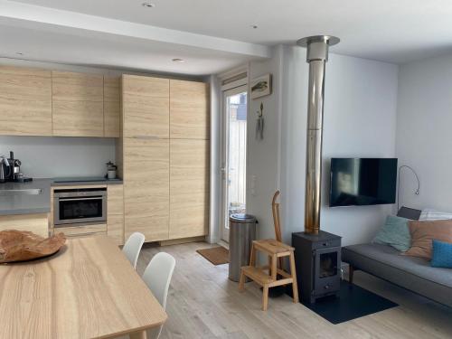a kitchen and living room with a table and a couch at White Sand Beach in Bergen aan Zee