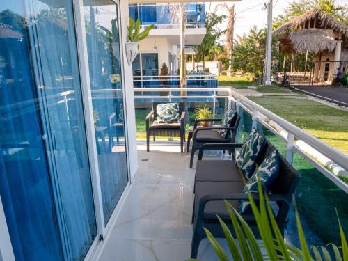 a balcony with chairs and tables on a house at Coconut Paradise Beach Hotel in Pajarito