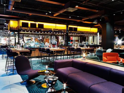 a restaurant with purple couches and tables and chairs at Scandic Europa in Gothenburg