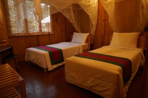 a room with two beds and a window at Lake Resort Bolgoda in Wadduwa
