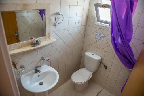 a bathroom with a white toilet and a sink at Summer Bed Nydri in Nydri