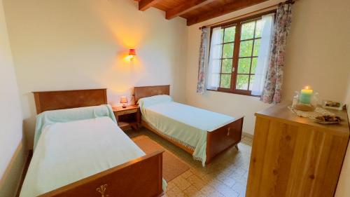 een slaapkamer met 2 bedden en een raam met een kaars bij location proche des plages in Sainte-Marie-de-Ré
