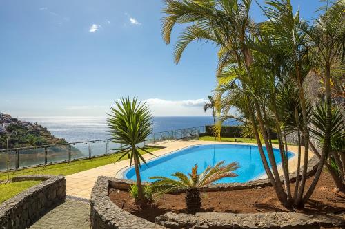 a swimming pool with a view of the ocean at Apartamento Vale e Mar in Calheta