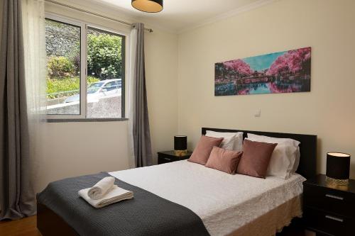 a bedroom with a bed and a large window at Apartamento Vale e Mar in Calheta