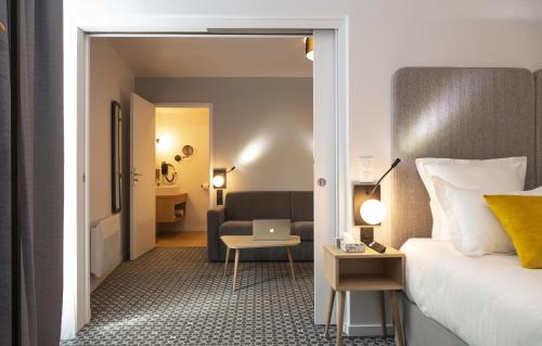 Pokój hotelowy z łóżkiem i krzesłem w obiekcie Odalys City Le Havre Centre Les Docks w Hawrze