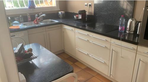 - une cuisine avec des comptoirs noirs et un évier dans l'établissement A deux pas de la Mer, à Marseille