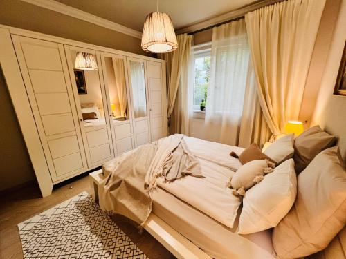 1 dormitorio con 1 cama blanca grande y ventana en MVS Apartment, en Giroc