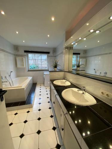 a large bathroom with two sinks and a tub and a tubermott at Dachwohnung mit Wasserblick und eigenem Bootssteg in Berlin