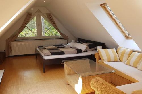 a attic room with a bed and a couch at Dachwohnung mit Wasserblick und eigenem Bootssteg in Berlin