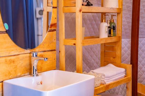 a bathroom with a sink and a mirror at De Vivre Homestay Măng Đen in Kon Von Kla