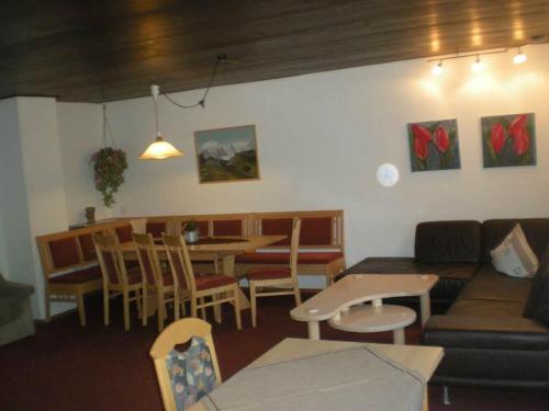 a living room with a couch and a table and chairs at Haus Gant in Sankt Gallenkirch