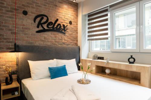 a bedroom with a bed with a brick wall at Valaoritou 3 Luxury Rooms in Thessaloniki