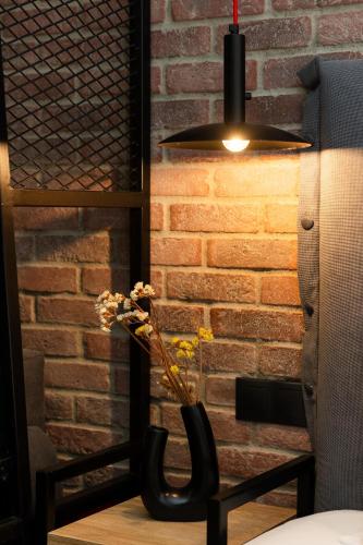 a vase with flowers in it next to a brick wall at Valaoritou 3 Luxury Rooms in Thessaloniki