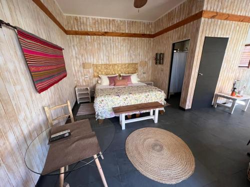 a bedroom with a bed and a table and a rug at Cabañas Miraelqui in Pisco Elqui