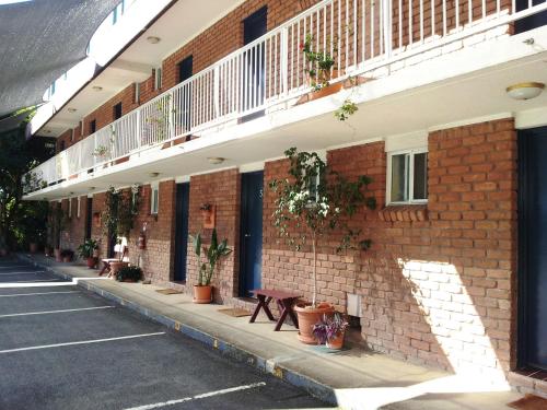 
a large brick building with a bench on the side of it at Aquajet Motel in Coffs Harbour
