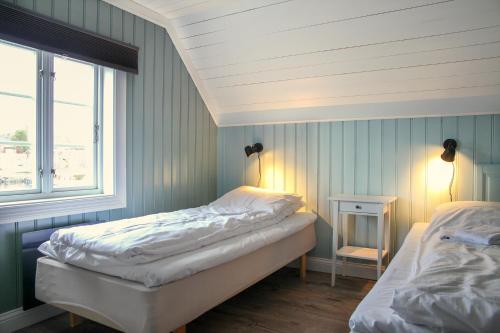 a bedroom with two beds and a window at Hotel Lyngørporten in Gjeving