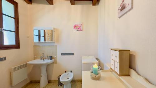 een badkamer met een wastafel, een toilet en een spiegel bij location proche des plages in Sainte-Marie-de-Ré