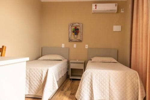 Cette chambre comprend 2 lits et une fenêtre. dans l'établissement Vila Germânia, Casa Berlim, à Pirenópolis