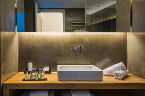 a bathroom with a large white sink on a wooden counter at Grace Mykonos in Agios Stefanos