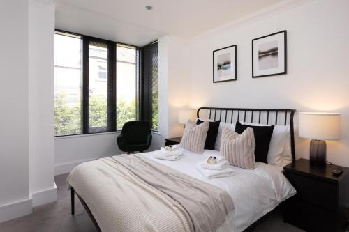 um quarto com uma grande cama branca e uma cadeira em London Mews, modern apartment - sleeps 4 em York
