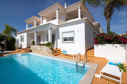 a villa with a swimming pool in front of a house at Villa Ílios - Porto de Mós, Lagos in Lagos