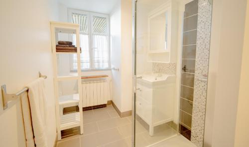 une salle de bain avec une douche en verre et un lavabo dans l'établissement La Petite Bachelière - terrasse couverte extérieure et jacuzzi, à La Bachellerie