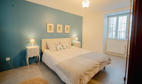 une chambre avec un lit avec deux tables de nuit et deux lampes dans l'établissement La Petite Bachelière - terrasse couverte extérieure et jacuzzi, à La Bachellerie