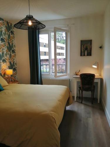 een slaapkamer met een bed, een bureau en een raam bij Appartement aux Portes de St Goustan in Auray