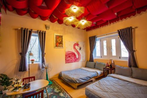 a living room with red ceilings and a bed and a table at De Vivre Homestay Măng Đen in Kon Von Kla