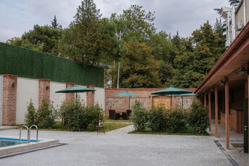 a courtyard with umbrellas and a swimming pool at Hotel Piano Kvareli in Kvareli