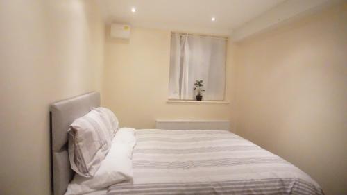 a white bed in a room with a window at One Bedroom Apartment at Islington in London