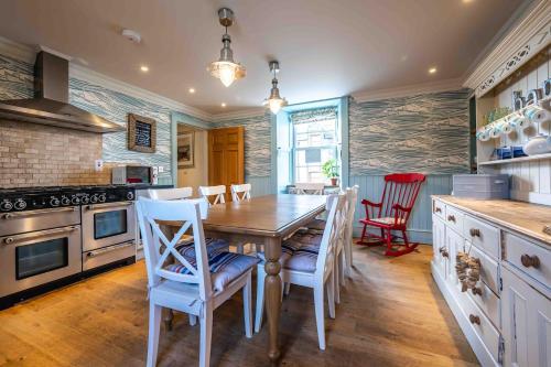 a kitchen with a wooden table and chairs and a stove at The Millie Luxury Five Star with Sea View in Burghead