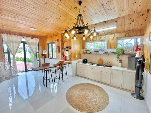 a kitchen with wooden ceilings and a table and chairs at Là Lá La Home in Da Lat