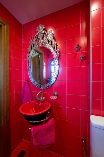 a red bathroom with a red sink and a mirror at Archontiko Alexandros Luxury Suites in Kardiá